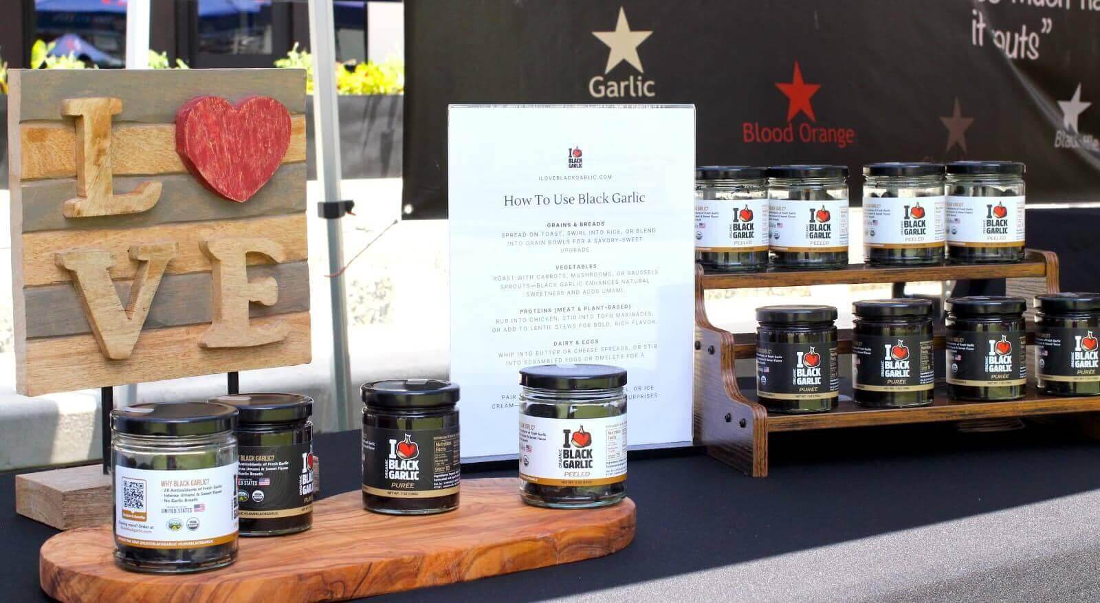 Display of black garlic jars at a market. Where to Buy Black Garlic online and in Atlanta markets.